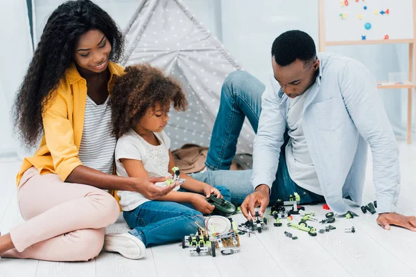 Afroamericanos Padres Sentados Suelo Con Hija Cerca Juguetes Plástico —  Fotos de Stock