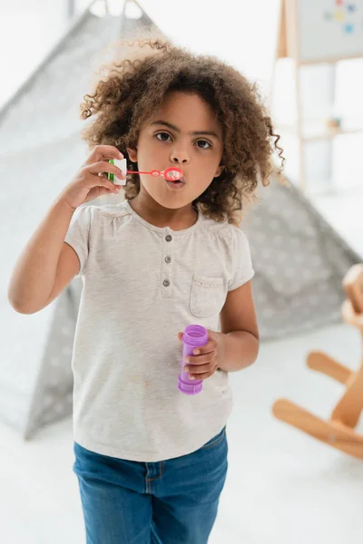 Curly African American Kid Blowing Soap Bubbles Looking Camera — Stock Photo, Image
