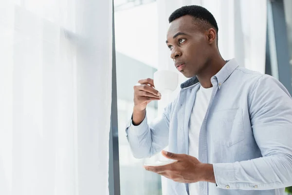 Hombre Afroamericano Sosteniendo Taza Con Café Platillo Casa — Foto de Stock