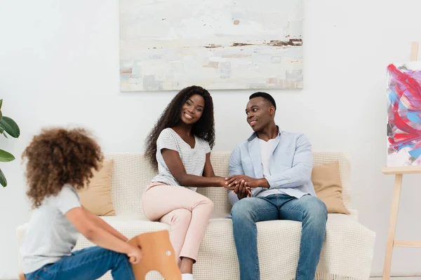 Selective Focus African American Parents Holding Hands Looking Kid Sitting — Stock Photo, Image