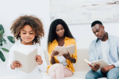 Afrika kökenli Amerikalı çocuğun ailesinin yanında kitap okumasının seçici odağı. 