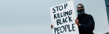 Panoramik konsept Afro-amerikan bir adamın pankart tutması ve dışarıdaki siyahları öldürmeyi bırakması. 