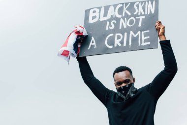 Amerika bayrağı ve siyah derili afro pankart taşıyan Afro-Amerikan erkeği dışarıda yazılı bir suç değil.