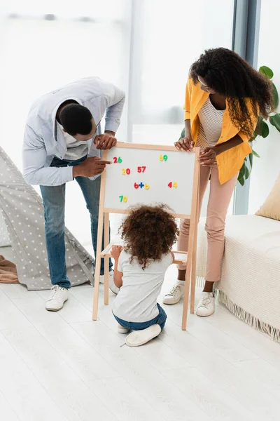 Afrikaans Amerikaanse Vader Wijzend Met Vinger Naar Magneet Whiteboard Buurt — Stockfoto