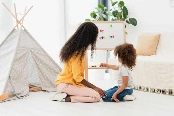 Rizado Africano Americano Niño Tocando Imán Cerca Pizarra Blanca Morena — Foto de Stock