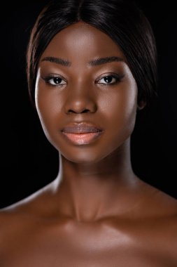 Siyah üzerine izole edilmiş kameraya bakan Afro-Amerikan çıplak kadın portresi.