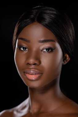 Siyah üzerine izole edilmiş kameraya bakan Afro-Amerikan çıplak kadın portresi.