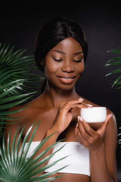 African American Woman Applying Cosmetic Cream Green Palm Leaves Isolated — Stock Photo, Image
