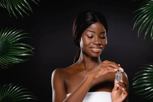 African American Woman Holding Bottle Serum Green Palm Leaves Isolated — Stock Photo, Image