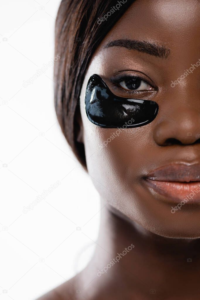 cropped view of african american woman with hydrogel eye patches on face isolated on white
