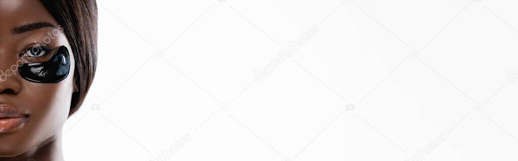 cropped view of african american woman with hydrogel eye patches on face isolated on white, panoramic shot