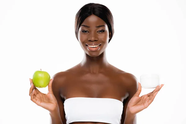 非洲裔美国妇女 手里拿着成熟的绿色苹果和用白色隔开的化妆品霜 — 图库照片
