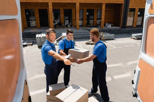 Selective Focus Loader Clipboard Pen Pointing Hand Colleagues Carton Boxes — Stock Photo, Image