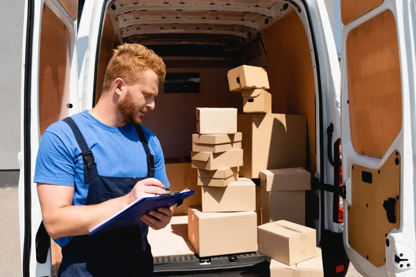 Lader Overalls Met Klembord Bij Vrachtwagen Met Pakketten Buiten — Stockfoto