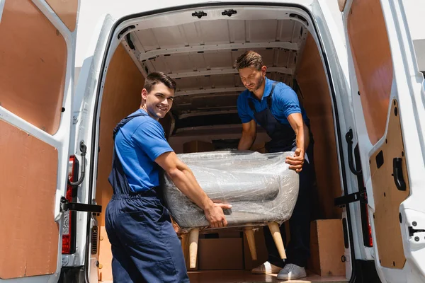 Loader Looking Camera While Holding Armchair Colleague Truck Outdoors — Stock Photo, Image