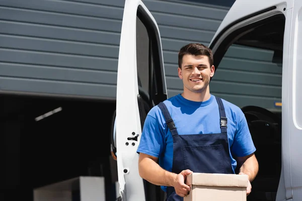 Junger Lader Hält Karton Der Hand Und Schaut Kamera Der — Stockfoto