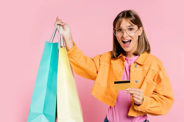 Excited Woman Yellow Jacket Sunglasses Holding Colorful Shopping Bags Credit — Stock Photo, Image