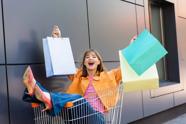 Selektivt Fokus Upphetsad Ung Kvinna Tittar Kameran Medan Håller Shoppingväskor — Stockfoto