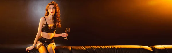 Çamaşırlı Kanepede Oturan Elinde Siyah Şarap Kadehiyle Baştan Çıkarıcı Bir — Stok fotoğraf