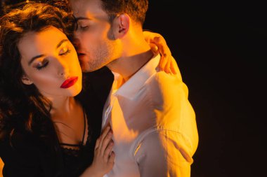 Gömlekli bir adamın siyah gözleri kapalı bir kadını öptüğü yüksek açı. 