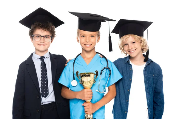 身着不同职业服装戴着毕业帽的孩子们 手里拿着一个白色的奖杯 — 图库照片