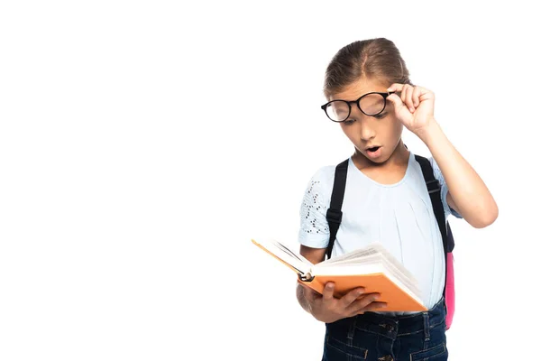 Geschokt Schoolmeisje Aanraken Bril Tijdens Het Lezen Boek Geïsoleerd Wit — Stockfoto