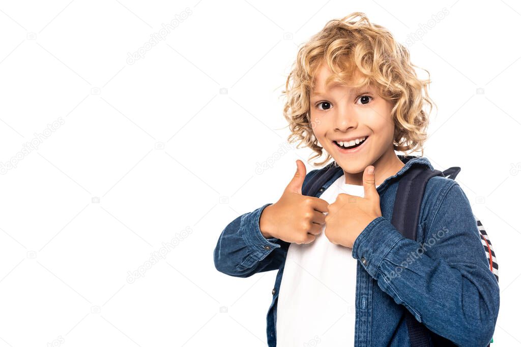 curly blonde schoolboy looking at camera and showing thumbs up isolated on white 