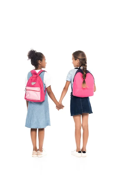 Back View Multicultural Schoolgirls Backpacks Holding Hands Standing Isolated White — Stock Photo, Image