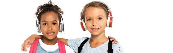 白に隔離されたワイヤレスヘッドフォンで音楽を聴く多文化の子供たちのパノラマ写真 — ストック写真