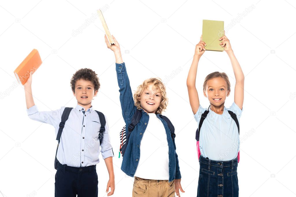 curly schoolboys and schoolgirl holding books above heads isolated on white 