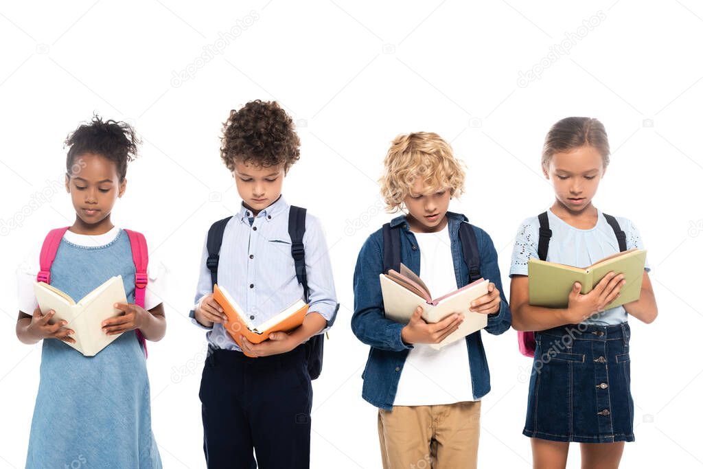 multicultural and curly schoolkids reading books isolated on white 