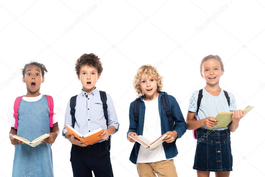 multicultural and shocked schoolkids holding books isolated on white 