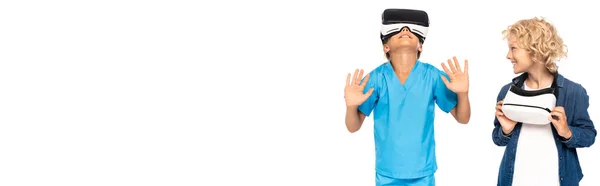 Panoramautgrep Med Krøllete Gutt Som Ser Barn Virtuelle Virkelighetshodetelefoner Isolert – stockfoto