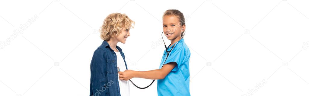 panoramic shot of child in costume of doctor examining curly boy isolated on white 