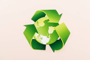 top view of green recycling symbol with planet isolated on beige clipart