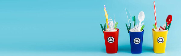 разноцветные контейнеры для переработки с пластиком на голубом фоне, панорамный снимок