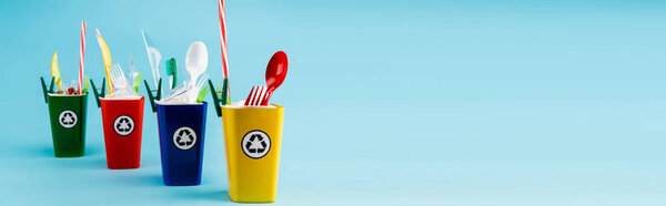 разноцветные контейнеры для переработки с пластиком на голубом фоне, панорамный снимок