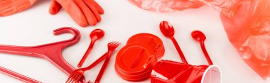 Beyaz arkaplana saçılmış kırmızı plastik nesneler, panoramik çekim