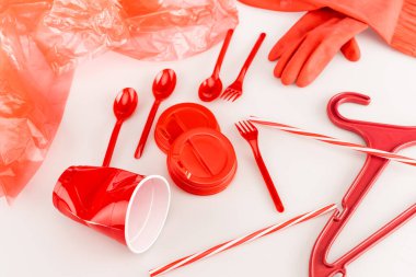 beyaz arkaplana dağılmış kırmızı plastik nesneler