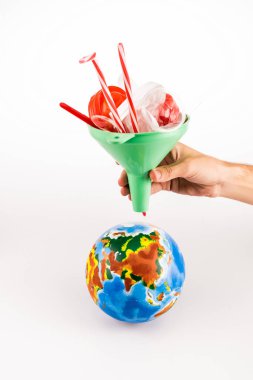 Beyaz arka planda, plastikle kaplı huni tutan insan görüntüsü.