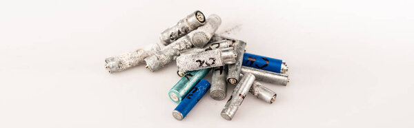 pile of used batteries on white background, panoramic shot