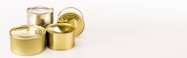 metal golden tins on white background, panoramic shot