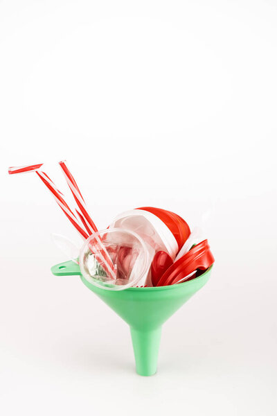 red plastic objects in funnel on white background