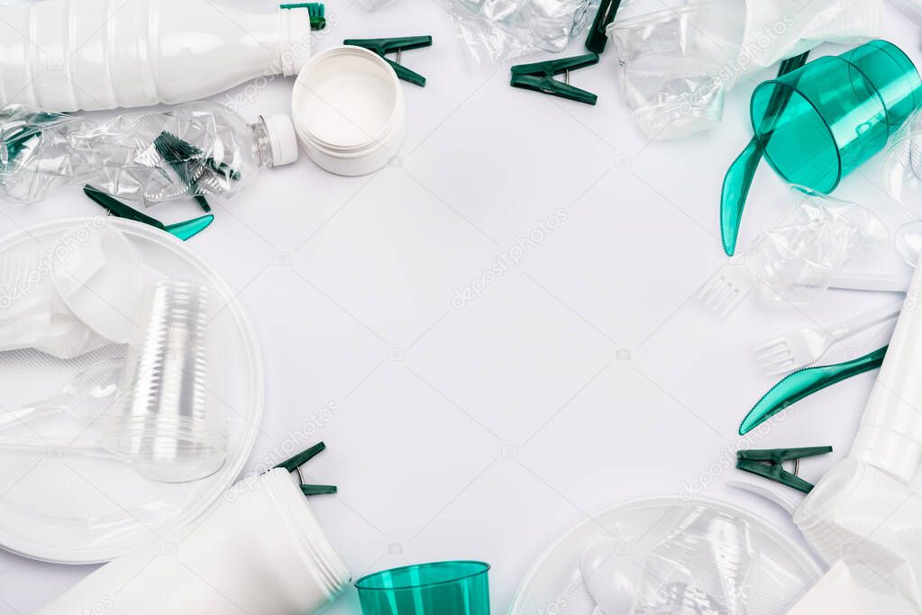 top view of plastic rubbish scattered on white background with copy space
