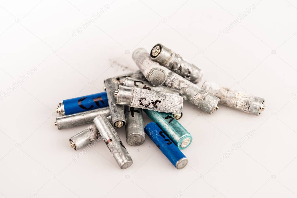 pile of used batteries on white background
