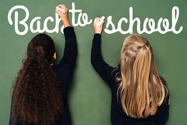 Back View Multicultural Schoolgirls Writing Back School Lettering Chalkboard — Stock Photo, Image