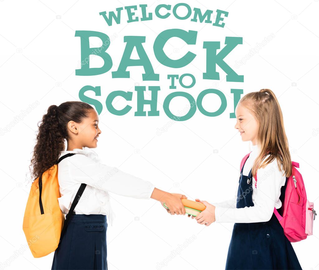 side view of african american schoolgirl giving books to smiling friend isolated on white, welcome back to school illustration