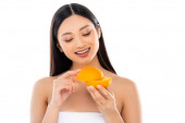 young asian woman holding halves of ripe orange isolated on white