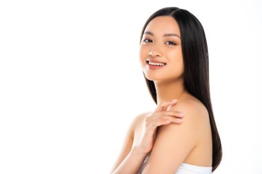 Asian woman touching shoulders and looking at camera isolated on white  clipart