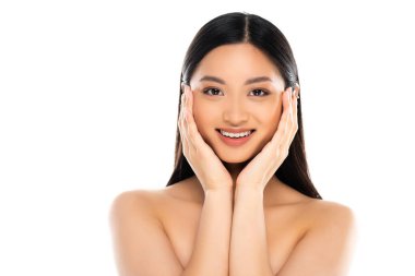 Neşeli Asyalı kadın kameraya bakıyor ve beyaz tenli yanaklara dokunuyor 